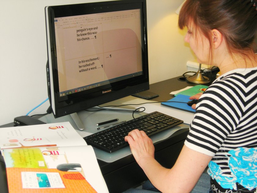 A photo of Elvira typing text onto the right hand side of the page of the document on screen leaving the left free for the adapted images from the book Up and Down by Oliver Jeffers